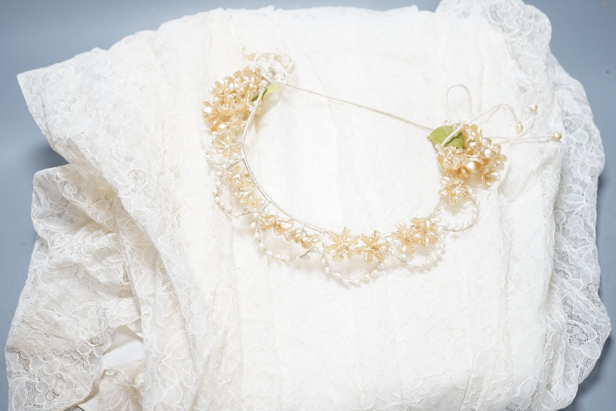 A late 1930's- 40's cream machine lace wedding dress and petticoat together with a pear listed floral tiara/ headdress.